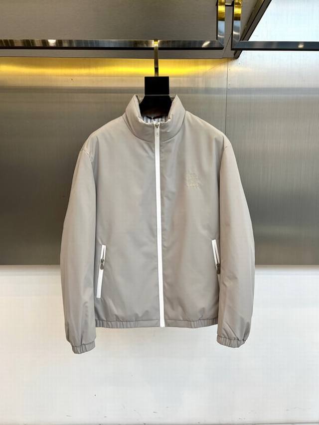 Brunello Cucinelli-Bc、2025秋冬系列羽绒外套。本款浅灰色立领夹克，凭借其纯粹线条与考究细节，定义现代日常着装。采用100%棉质面料构筑挺