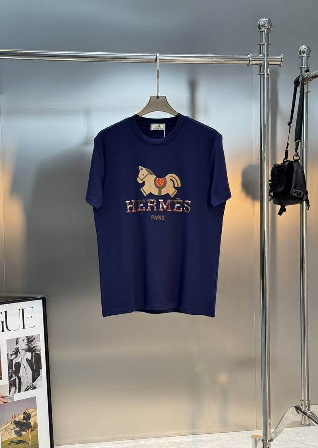 爱马仕 HermèS 品牌的马术Logo莫代尔印花T恤.它的设计灵感来源于品牌标志性的马术运动，胸前印有抽象的橙色小马图案，搭配“HermèS paris”字样