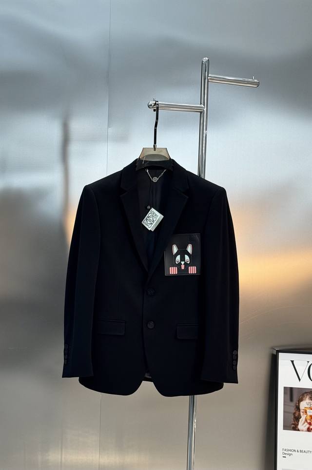 Loewe*罗意威新款西装 采用经典单排两粒扣设计，剪裁利落，线条流畅，简约又高级。左胸皮口袋的卡通狗图案超有趣，为正式风格增添个性和趣味感。面料为高品质四面弹