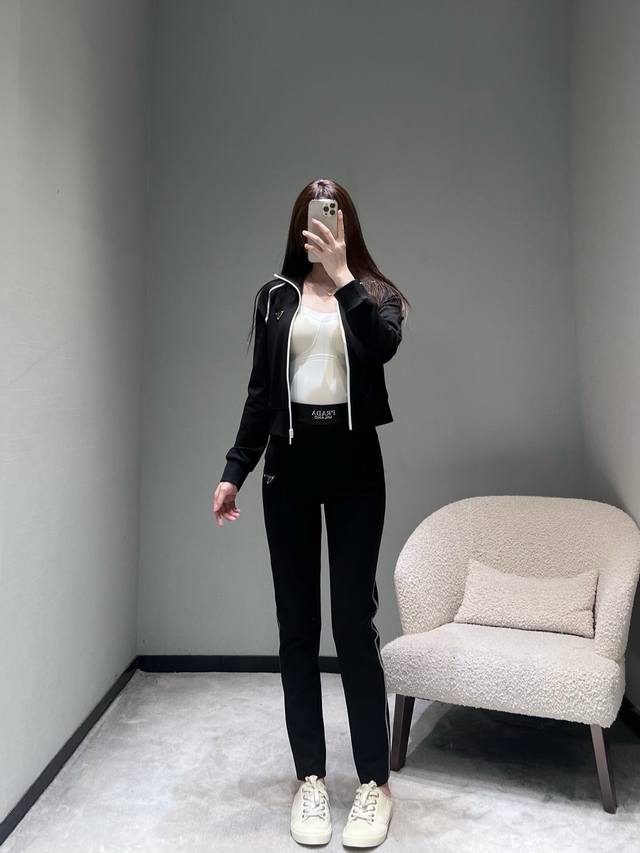 prad*2025Fw秋冬新品系列 运动套装：上衣是立领款，白色镶边+侧边银灰条纹，打破纯黑的沉闷感。左胸经典三角标设计；束脚裤同样细节满满：腰头印有pd字母L