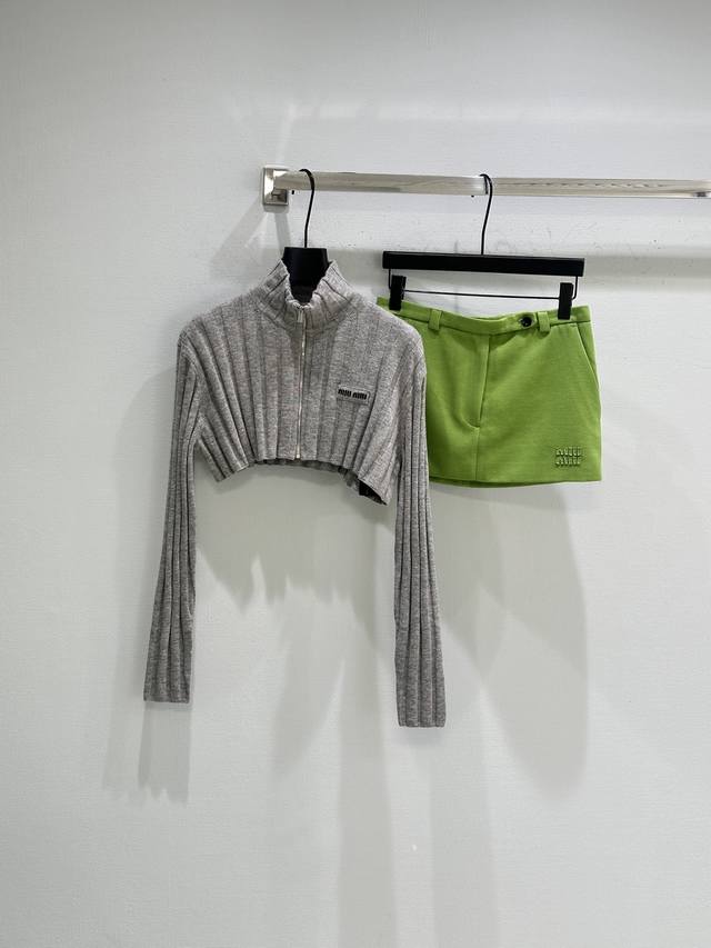 25Ss冬季新款上新！Miu档案廓形在这款短款罗纹针织开衫中被重新诠释，采用柔软的再生羊毛和羊绒纱线，展现出清爽简约的精髓。这件服装融合了过去的风格密码和工艺创