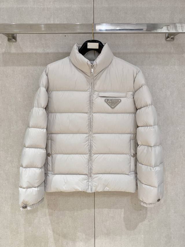特级羽绒Prada 科技轻质面料风羽绒外套.采用鹅绒填充原厂配套 DDD 产品详情 DDD Prada标志性的三角标Ogo，装点这款科技轻质抗撕裂面料羽绒外套。