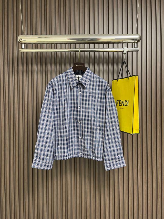 Miumiu 标致格纹翻领单排扣夹克外套，采用高支高密棉质面料，手感柔软顺滑，透气性与耐用性兼备；面料经特殊水洗工艺处理，呈现自然的复古质感与柔和光泽，细腻中透